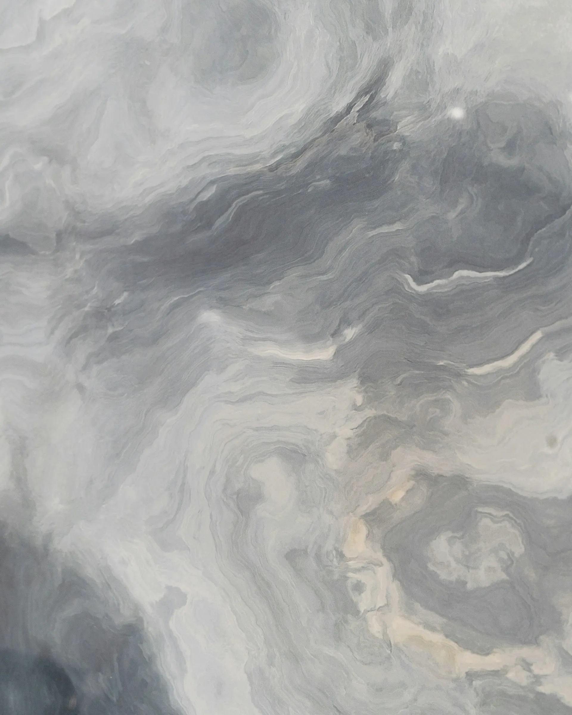 Close-up of a grey and white marble texture with swirling patterns.